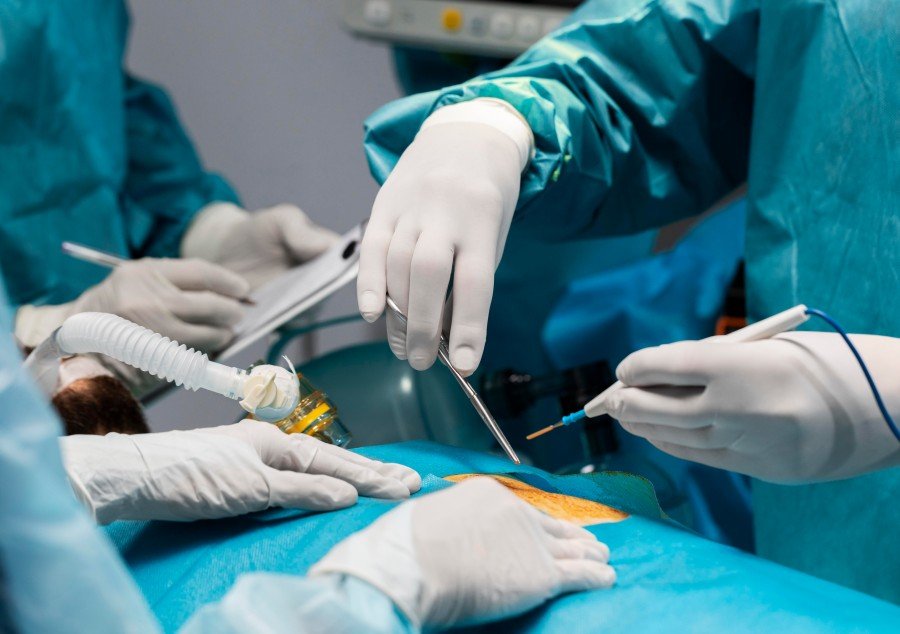 Medical team performing minimally invasive lipoma and cyst surgery in a sterile operating room.
