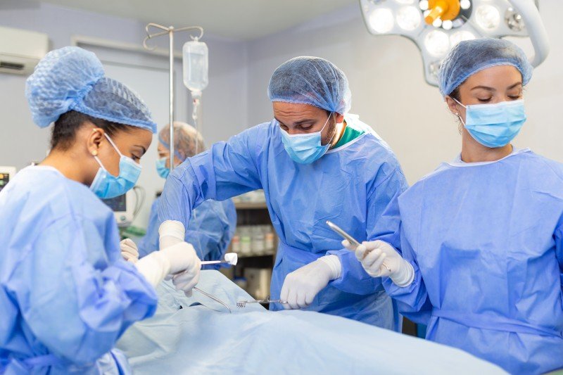Surgeons performing laparoscopic gallstone surgery in an operating room