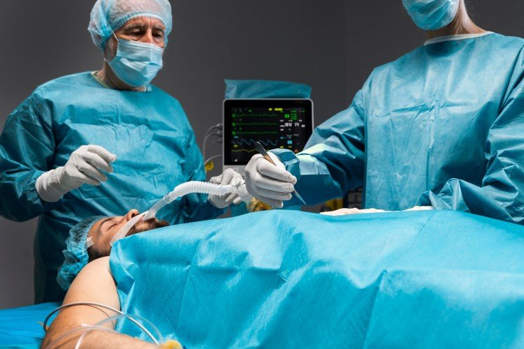 Surgeons in sterile gowns and masks performing Laparoscopic Gallstone Surgery in an operating room.