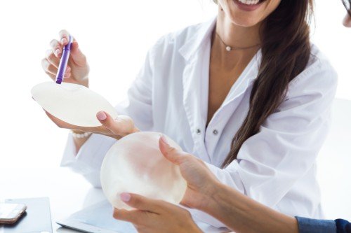 Breast Surgery consultation with a female doctor showing a breast implant to a patient